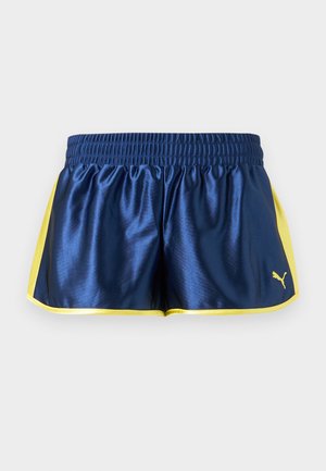 Μπλε σκούρο αθλητικό σορτς με κίτρινες πλαϊνές λωρίδες και επένδυση, ελαστική μέση και μικρό κίτρινο λογότυπο Puma στο κάτω δεξί μέρος.