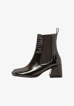 Bottines noires avec une finition en cuir brillant, des panneaux latéraux élastiques et un talon texturé gaufré crocodile. Design à bout carré.