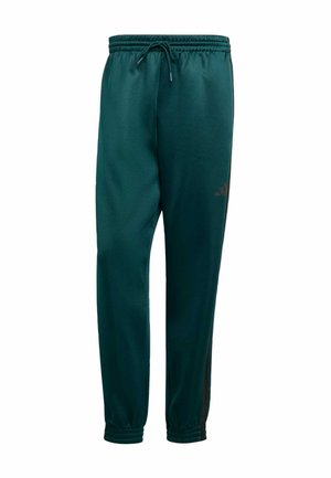 Pantalons de sport vert foncé en tissu lisse, dotés d'une taille élastique avec cordon de serrage, d'ouvertures de jambes fuselées et d'accents noirs sur les côtés.