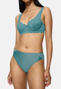Koronkowy biustonosz i pasujące majtki w kolorze t-aqua. Biustonosz ma falbany na brzegach oraz skomplikowany wzór z koronki. Majtki mają koronkowe akcenty przy pasku.