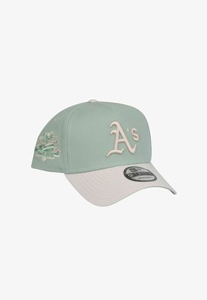Light green baseball cap with a white visor. Features embroidered "A's" logo and decorative patch on the side. Adjustable back.