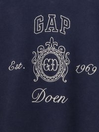 Granatowa bluza z białym haftowanym napisem: "GAP", "Est. 1969" oraz "Doen", z dekoracyjnym okrągłym wzorem na środku.