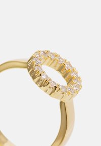 Guld ring med ett runt band med en texturerad yta och en cirkulär topp prydd med klara, glittrande stenar i en klorinställning.