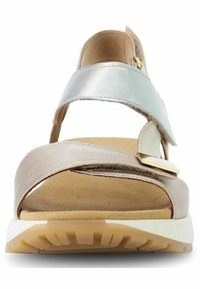 Sandalo con cinturini in argento metallico e beige, soletta morbida, suola chiara con scanalature testurizzate e fibbia dorata.