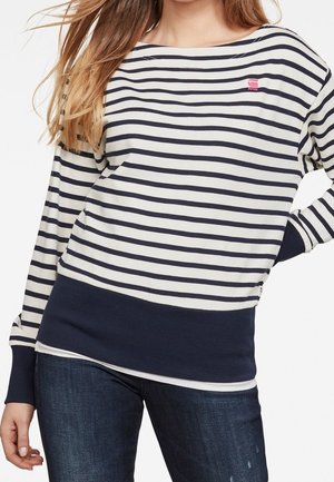 Maglia a maniche lunghe a righe in crema e blu navy. Presenta righe orizzontali, un orlo a coste blu navy e un piccolo logo sul petto.