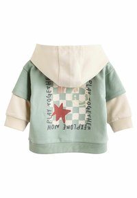 Kapuzenpullover mit mintgrünem Körper und cremefarbenen Ärmeln, mit grafischem Druck, der ein Smiley-Gesicht, einen Stern und Text zeigt. Weiches Baumwollmaterial.