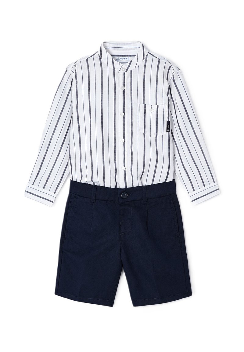 Camicia button-up a righe bianca e blu navy, con taschino sul petto, abbinata a pantaloni corti blu navy scuro con chiusura anteriore a bottone.