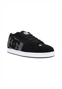 Schwarzer Sneaker mit strukturierten schwarzen und grauen Paneelen, ausgestattet mit einer weißen Sohle und einem auffälligen Logo an der Seite. Runde Zehenform und Schnürdesign.