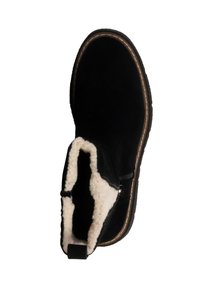 Zwarte suède enkellaars met een zachte witte bontvoering, zijrits en een contrasterende bruin gestikte zool. Ontworpen voor comfort en warmte.