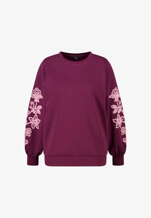 Sweat-shirt bordeaux avec manches longues bouffantes ; présente une broderie florale rose sur la manche gauche. Col et poignets côtelés ; texture douce.