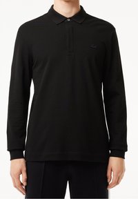 Langärmliges schwarzes Poloshirt aus Baumwolle, mit einer Knopfleiste mit drei Knöpfen, geripptem Kragen und einem kleinen, tonalen Logo auf der Brust.