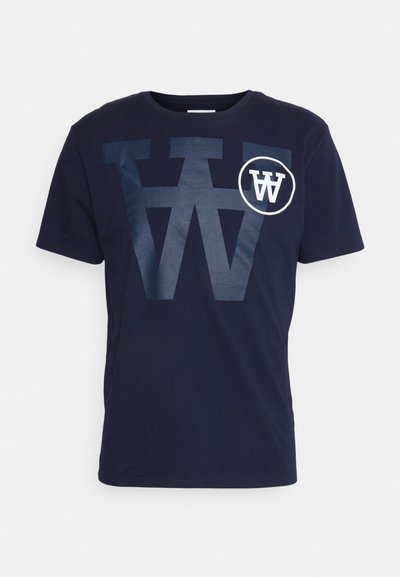 Granatowa bawełniana koszulka z dużym graficznym wzorem „W” w ciemniejszym niebieskim oraz okrągłym logotypem z „W” w białym na piersi. Krótkie rękawy, okrągły dekolt.