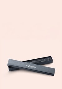 Grå rektangulär smyckeslåda med texturerad yta, lätt öppen, som avslöjar svart inre foder. Vit logotyp tryckt på locket.