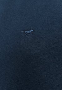 Maglietta in cotone blu navy con una texture liscia, caratterizzata da un piccolo logo di un cavallo ricamato in una tonalità leggermente più chiara.