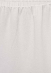 Witte stof met een gladde textuur, lichtjes gathered aan de bovenkant. Het materiaal lijkt zacht en lichtgewicht, geschikt voor casual kleding.