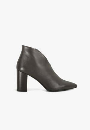 Stivaletti alla caviglia in pelle nera con punta appuntita e tacco a blocco alto. Presentano una silhouette elegante e una texture liscia.