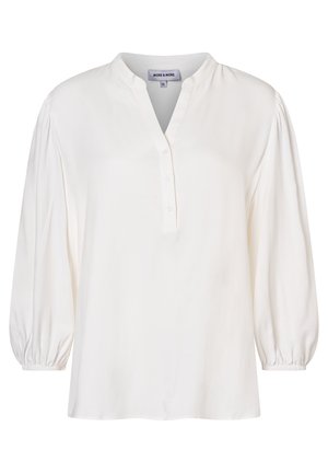 Blouse blanche en tissu doux avec un décolleté en V, une patte de boutonnage et des manches volumineuses froncées aux poignets. Texture lisse.
