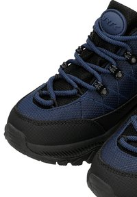 Sneakers blu e neri con tessuto testurizzato, suola in gomma nera spessa, motivo trapuntato e un robusto sistema di allacciatura.