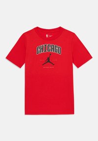 Camiseta de algodón roja con un estampado gráfico negro de la palabra "CHICAGO" y un logotipo en silueta en el centro. Manga corta, cuello redondo.