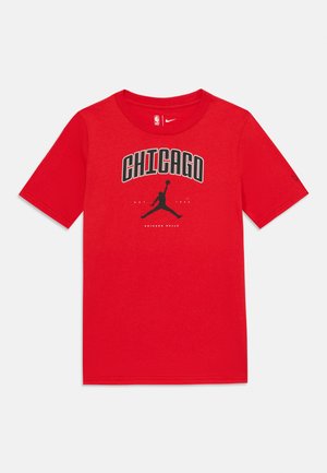 Raudona medvilninė marškinė su juodu grafikiniu spaudiniu, ant kurio užrašyta "CHICAGO", o centre yra silueto logotipas. Trumpomis rankovėmis, apvaliu iškirpimu.