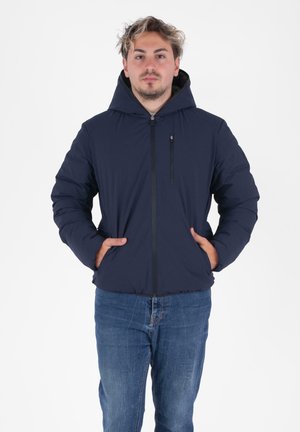 Marineblauwe pufferjack met een ritssluiting aan de voorkant, een grote capuchon en zijzakken. Heeft een zachte textuur en elastische manchetten voor warmte en comfort.