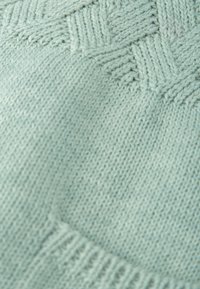 Suéter de punto azul claro con un patrón texturizado y una tela suave. Los detalles incluyen bordes acanalados y un acabado suave.
