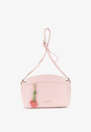 Jasnoróżowa skórzana torebka na ramię z regulowanym paskiem i zawieszką na suwak w kształcie wiśni, złote tłoczone logo marki na froncie.