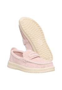 Zapatos rosa claro sin cordones con tela texturizada, un diseño cosido y una suela de goma beige con patrones de agarre.