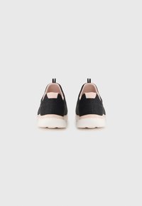 Melni slip-on sporta apavi ar strukturētu audumu, rozā akcenti uz papēža un balta gumijas zole. Iespējas ietver ievelkšanas cilpu un minimālistisku dizainu.