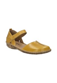 Zapato de cuero amarillo con tira cruzada en el tobillo y punta redonda. Presenta una suela texturizada y detalles cosidos en la parte superior.