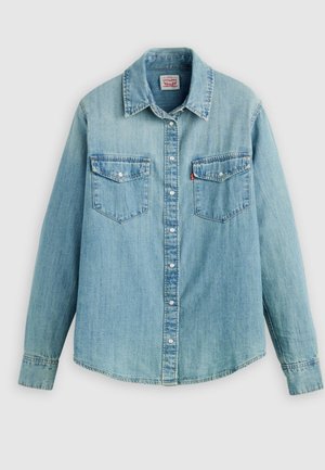 Svijetloplava jeans košulja s klasičnim ovratnikom, zatvaranjem na prednje kopče, dva džepa na prsima i manžetama s gumbima te blago zaobljenim rubom.