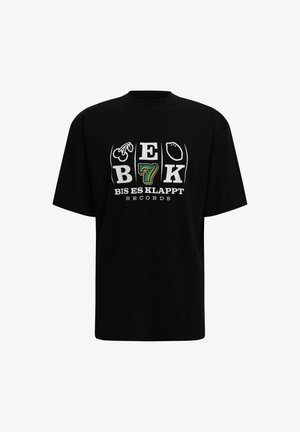 Must t-särk mustast puuvillast, millel on graafiline disain tekstiga "BEK 7 BIS ES KLAPPT RECORDS" ning erinevad sümbolid valgete ja roheliste toonidega.