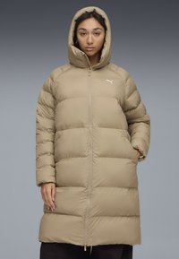 Giacca a vento beige con cappuccio, caratterizzata da cuciture orizzontali, zip frontale e tasche laterali. Piccolo logo sul petto. Texture morbida.