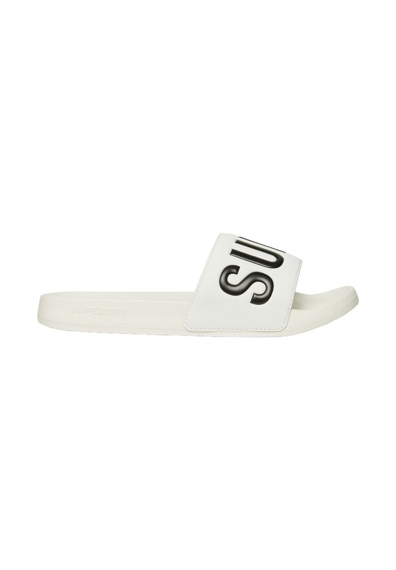 Sandalo bianco con una larga fascia che presenta testo nero. Realizzato in materiale sintetico, suola piatta e design minimale. Texture liscia.