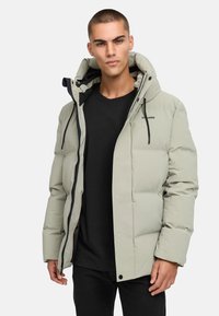 Šviesiai pilka pūkinė striukė su kapišonu, užtrauktuku ir spaudėmis. turi juodus akcentus ir vientisą spalvų dizainą.