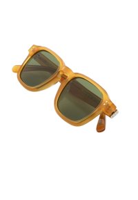 Occhiali da sole con una montatura quadrata traslucida giallo-arancione e lenti verde scuro. Caratteristiche includono aste prominenti e un discreto logo.