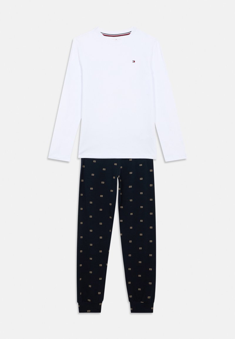 Langærmet hvid bomulds skjorte med rund hals, parret med marineblå bomuldsbukser med et mønster af lys symboler.