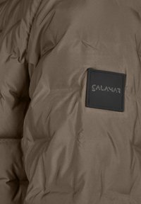 Giacca a vento marrone con una texture liscia, dotata di un'etichetta nera quadrata impressa con il nome del marchio "CALAMAR."