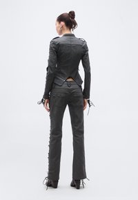 Hall hall teksariidest jakk, millel on keha järgnev lõige, varrukatel pitsistus ja sellele sobivad hallid teksapüksid koos külgpitsidega. Nelinurksete ninadega saapad.