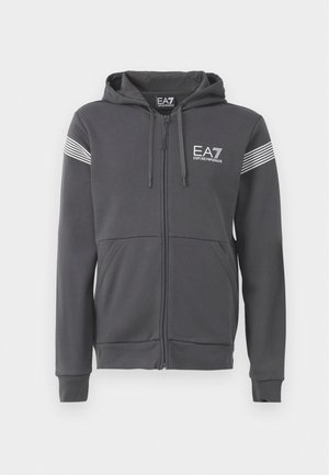 Grå hettejakke med glidelås laget av myk stoff. Har en logo foran, stripete detaljer på ermene og kengurulommer.