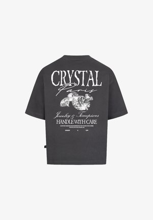 T-shirt nera oversize con maniche corte. Presenta una grande grafica testuale bianca e illustrazioni di diamanti sul retro. Materiale in cotone morbido e casual.