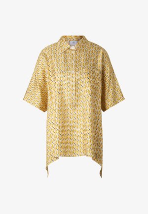 Gul kortærmet skjorte med knapper, geometrisk hvidt og brunt mønster, spids krave og asymmetrisk kant på begge sider.