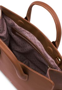 Braune Lederhandtasche mit zwei Griffen. Das Innere verfügt über ein weiches mauvefarbenes Futter mit Punkten und eine Reißverschlusstasche zur Organisation.