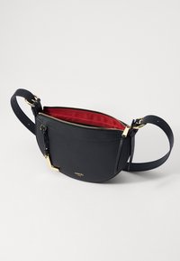 Crni kožni crossbody ranac s zlatnim hardverom i crvenim unutarnjim dio. Ima zatvaranje na patentni zatvarač i podesivu traku za udobno nošenje.