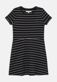 Čierne šaty s krátkym rukávom a bielymi horizontálnymi pruhmi, okrúhlym výstrihom a rozšírenou sukňou. Obsahuje malé logo na hornej ľavej strane.