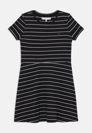 Robe à manches courtes rayée noir et blanc avec un col rond et une jupe évasée, confectionnée dans un tissu côtelé doux. Comprend un petit logo.