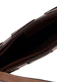 Braune Leder-Handtasche mit strukturiertem Finish, Reißverschluss und Innenfach. Verfügt über goldene Hardware und einen glatten Gurt. Das Innenfutter ist dunkel.