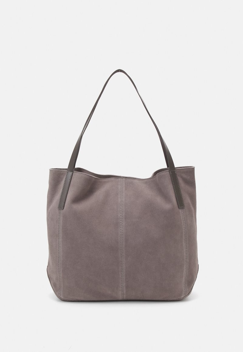 Sac fourre-tout en daim gris avec deux poignées foncées, des détails de coutures verticales et un corps spacieux légèrement tombant sur un fond uni.