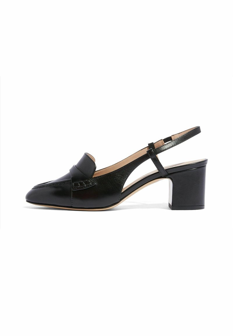 Zapato de tacón de piel negra con talón ancho, punta cerrada y detalle de corte lateral, mostrado sobre fondo blanco.