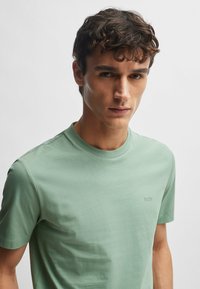 Korte mouwen crewneck T-shirt in lichtgroene katoenmix, met subtiele logo borduring op de borst, een gladde textuur en een relaxte pasvorm.